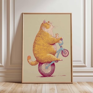 K&ouml;nnte beinhalten: Gerahmter Kunstdruck mit einer skurrilen Illustration einer gro&szlig;en, orangefarbenen Katze, die ein blaues Fahrrad f&auml;hrt, mit einer kleineren Katze als Beifahrer. Das Kunstwerk hat einen Vintage-Stil, mit beigem Hintergrund und Holzrahmen. Die Katze ist das Hauptmotiv.