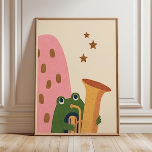 Op de afbeelding: Een ingelijste kunstdruk met een grillige illustratie. Een groene kikker speelt een tuba, naast een roze, gestippelde vorm en drie gouden sterren. Het kunstwerk heeft een getextureerde, vintage esthetiek, met een crèmekleurige achtergrond.