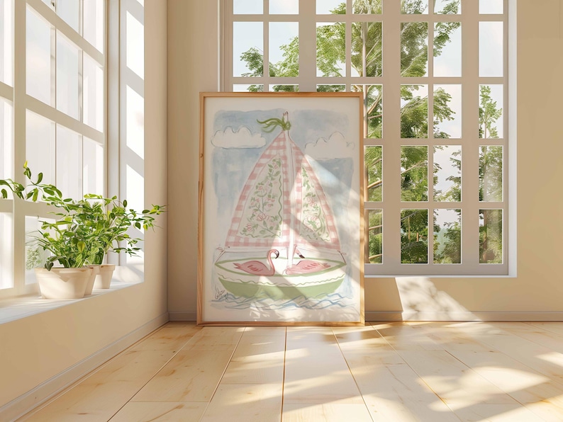 May include: Watercolor painting of a sailboat with a pink and white checkered sail, floral details, and two pink flamingos. The artwork is in a wooden frame, set against a window with natural light and greenery.
