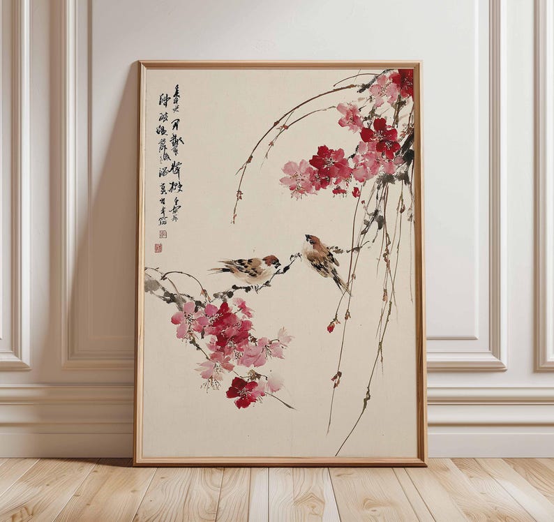Peut inclure: &OElig;uvre d'art encadr&eacute;e repr&eacute;sentant une peinture de style asiatique traditionnel. L'&oelig;uvre repr&eacute;sente trois petits oiseaux perch&eacute;s sur des branches avec des fleurs roses et rouges. Calligraphie visible sur le c&ocirc;t&eacute; gauche.
