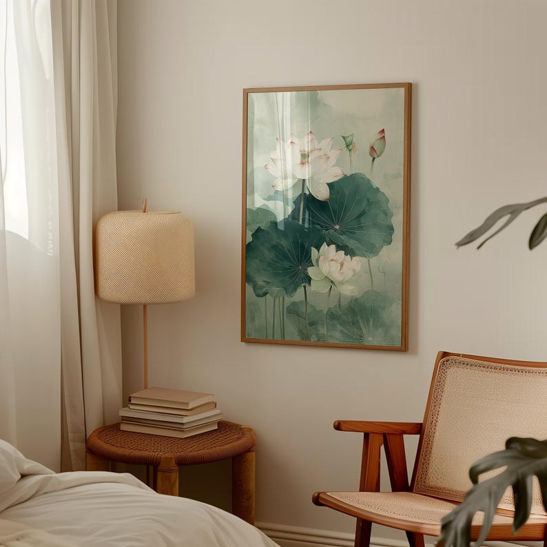 Puede incluir: Una pintura de acuarela enmarcada de flores de loto blancas y hojas verdes grandes. La obra de arte tiene una paleta de colores suaves y apagados con un fondo verde claro. La pintura se exhibe en una habitaci&oacute;n con una combinaci&oacute;n de colores neutros.