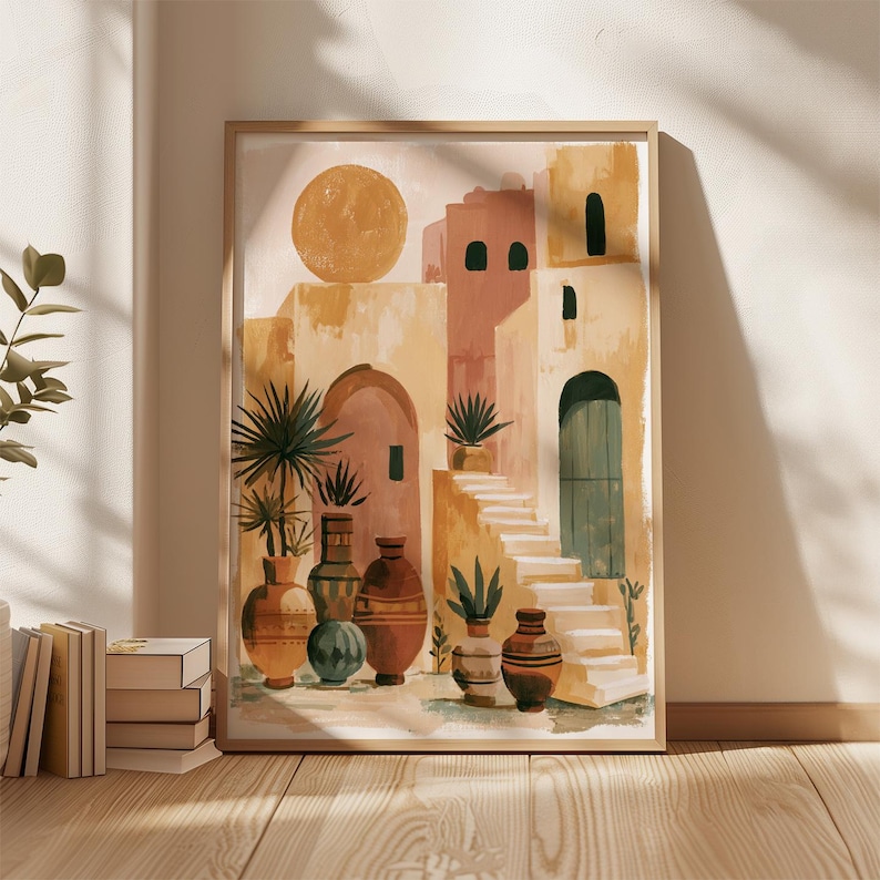 Peut inclure: Une affiche encadr&eacute;e repr&eacute;sentant un soleil et des b&acirc;timents aux tons p&ecirc;che, beige et jaune. L'&oelig;uvre pr&eacute;sente des arcades, des escaliers et des vases d&eacute;coratifs avec des plantes. L'affiche est expos&eacute;e sur un sol en bois.