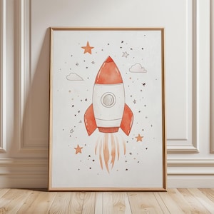 Könnte beinhalten: Aquarellillustration einer Rakete in einem goldenen Rahmen. Die Rakete ist rot und weiß mit orangefarbenen Flammen, umgeben von Sternen und Wolken. Das Kunstwerk ist ein skurriles Design zum Thema Weltraum.