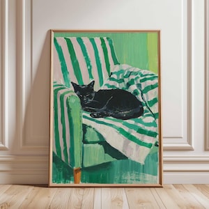 May include: A framed art print showing a black cat asleep on a green and white striped chair. The artwork includes a green and white striped blanket. The painting has a modern, illustrative style, with a focus on colour and form.