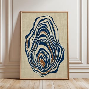 May include: A framed vertical wall art print featuring an abstract, organic oyster shell shape composed of layered, flowing lines in deep navy blue and warm brown tones, set against a textured, light beige linen-like background.