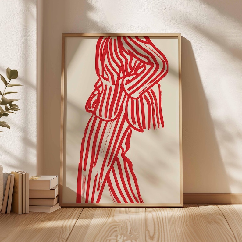 K&ouml;nnte beinhalten: Abstrakter Kunstdruck mit einer Figur in einem rot-wei&szlig; gestreiften Anzug. Das Kunstwerk ist in einem hellen Holzrahmen gerahmt und lehnt an einer Wand. Der Druck hat einen minimalistischen Stil und eine kr&auml;ftige Farbpalette.