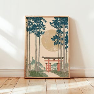 May include: Framed art print featuring a Japanese landscape with a red torii gate, a path, and tall trees with blue-green foliage. A large, pale yellow sun is in the background. The artwork is in a wooden frame.