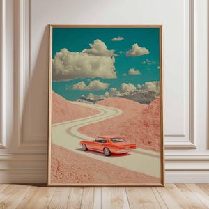 K&ouml;nnte beinhalten: Gerahmter Kunstdruck mit einem orangefarbenen Oldtimer, der auf einer kurvenreichen Stra&szlig;e durch rosafarbene Landschaften unter einem blauen Himmel mit Wolken f&auml;hrt. Das Kunstwerk hat einen Retro-Stil, wobei Farbe und Komposition im Mittelpunkt stehen.