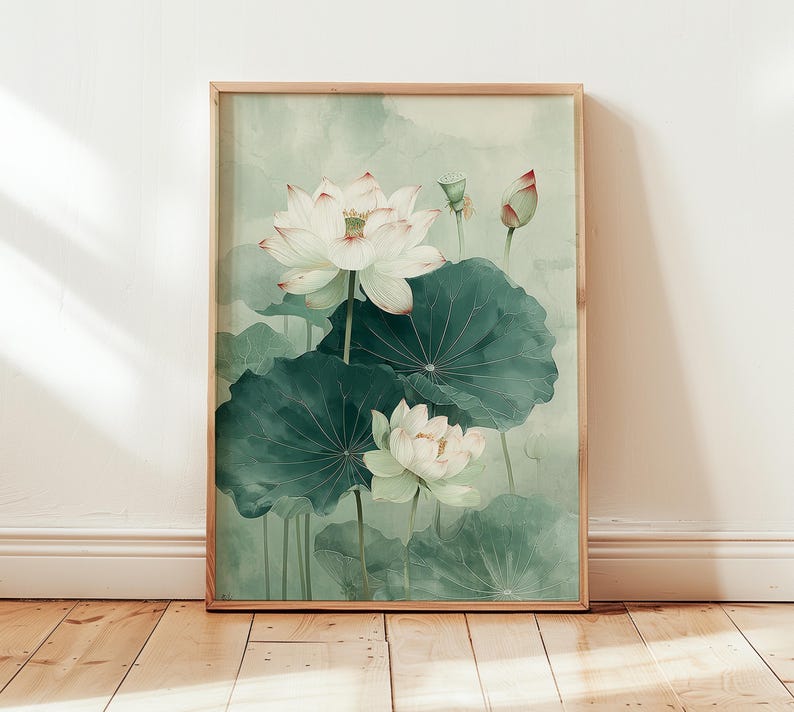 Puede incluir: Una impresi&oacute;n art&iacute;stica enmarcada que presenta una pintura de acuarela de flores de loto blancas con hojas verdes. La obra de arte tiene una paleta de colores suaves y apagados con tonos de verde, blanco y rosa. La pintura se muestra en un marco de madera.