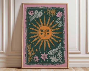 May include: Framed art print featuring a stylized sun with an orange face and rays, set against a dark green background. The design includes fish, flowers, and stars in white, orange, and pink, framed in a pink border.