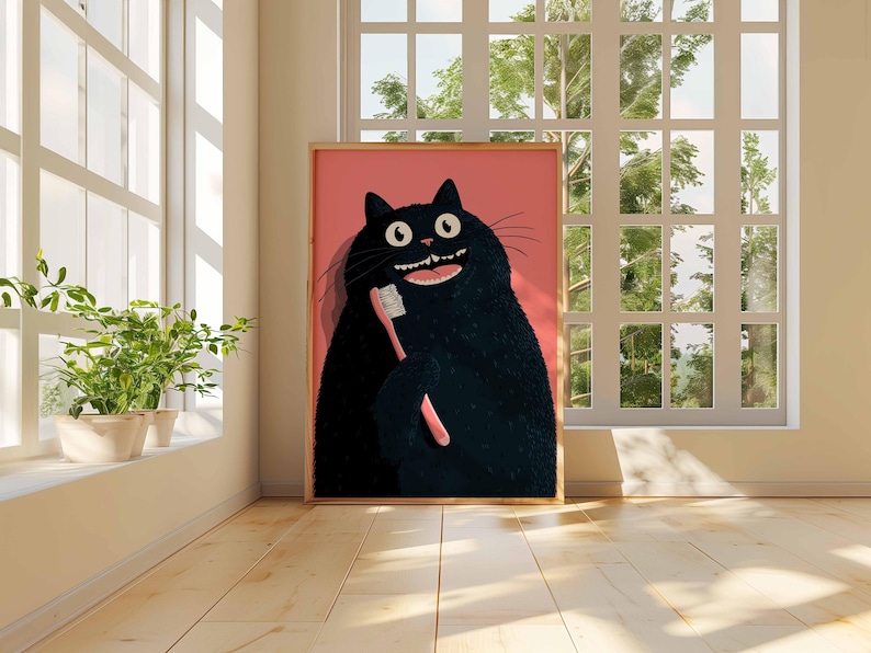 Op de afbeelding: Een ingelijste kunstdruk met een cartoon zwarte kat die een roze tandenborstel vasthoudt. De kat heeft een brede, tandige grijns en grote, ronde ogen. De achtergrond is effen roze. Het kunstwerk wordt getoond in een kamer met een raam en houten vloeren.
