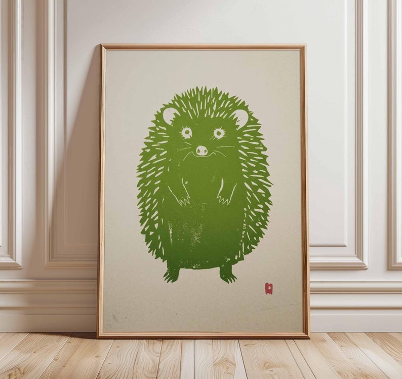 Pu&ograve; includere: Una stampa incorniciata con un'illustrazione di un riccio verde. Il riccio &egrave; raffigurato in uno stile linoleografico stilizzato con un aspetto strutturato. L'opera d'arte &egrave; ambientata su uno sfondo neutro e incorniciata in legno chiaro.