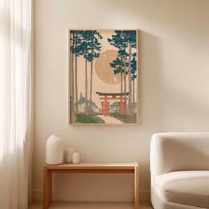 May include: Framed art print depicting a Japanese landscape with tall trees, a red torii gate, and a large, pale yellow sun. The artwork features a serene path leading towards the gate, with a soft, neutral color palette.
