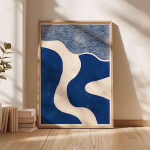 Puede incluir: Impresi&oacute;n art&iacute;stica abstracta en un marco de madera. La obra de arte presenta un dise&ntilde;o con formas azules y blanquecinas. La parte superior tiene l&iacute;neas horizontales, que se asemejan a olas. La impresi&oacute;n se muestra contra una pared blanca, con luz solar y sombras.