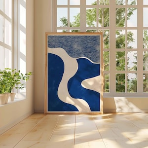 Puede incluir: Una impresi&oacute;n art&iacute;stica abstracta enmarcada con formas azules, blancas y beige. La obra de arte se exhibe en una habitaci&oacute;n con una ventana y luz natural. La impresi&oacute;n es rectangular y tiene un marco de madera.