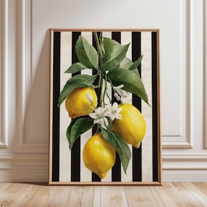 May include: Framed art print featuring a watercolor illustration of lemons with green leaves and white blossoms. The lemons are yellow, set against a black and white striped background. The frame is a light brown color.