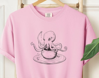 May include: Pink t-shirt with a black and white illustration of an octopus in a coffee cup.