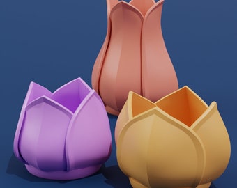 May include: Three ceramic flower-shaped vases in different colors: pink, purple, and yellow. The vases are arranged on a blue background.