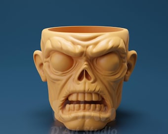 May include: A tan-colored, zombie-themed planter with a detailed, sculpted face. The planter features a wide open mouth, hollow eye sockets, and prominent cheekbones. The text "D'Art Studio" is visible at the bottom.