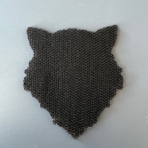 Pode incluir: Etiqueta preta de velcro em forma de cabe&ccedil;a de lobo.