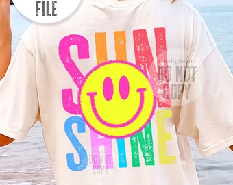 May include: A white t-shirt with a rainbow-colored graphic that says "SUN SHINE" with a yellow smiley face in the middle.