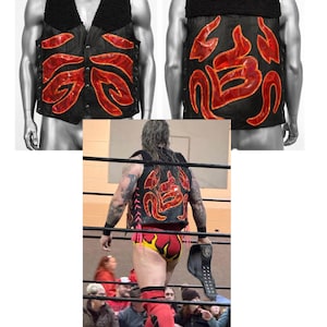 May include: A black vest featuring a black faux-shearling collar and red, flame-like iridescent appliques on the front and back. The vest includes a front button closure and side lacing details, displayed on a mannequin and worn by a wrestler.