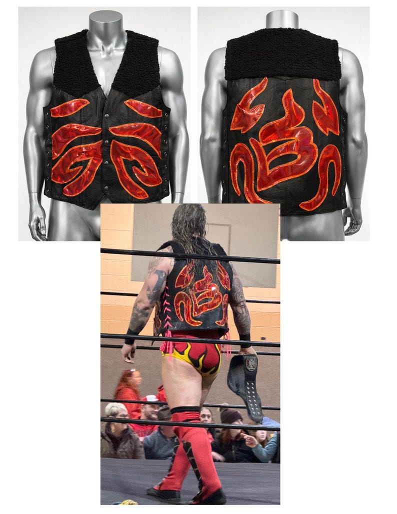 May include: A black vest featuring a black faux-shearling collar and red, flame-like iridescent appliques on the front and back. The vest includes a front button closure and side lacing details, displayed on a mannequin and worn by a wrestler.