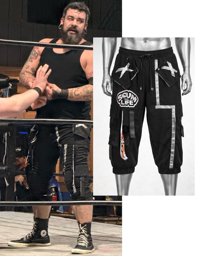 May include: Black cargo shorts featuring a drawstring waist, multiple pockets with silver X-shaped accents, and a prominent circular patch on the right leg displaying the text SCUM LIFE. The shorts include vertical silver reflective-style strips.