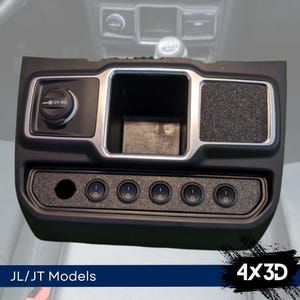 Könnte beinhalten: Schwarzes Kunststoffpanel mit silberner Einfassung und sechs Kippschaltern. Das Panel verfügt über ein kleines Ablagefach und eine 12V-DC-Steckdose.  JL/JT Models 4x3D