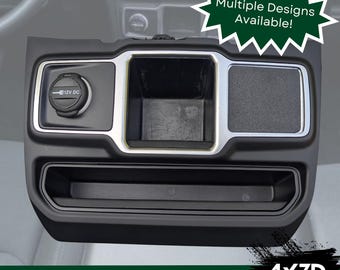 Könnte beinhalten: Schwarzer Auto-Konsolen-Organizer mit 12V DC-Steckdose, Staufächern und strukturierter Oberfläche. Der Text "Multiple Designs Available!" befindet sich in einer grünen Sternform. Die Texte "JL/JT Models" und "4x3D" sind ebenfalls sichtbar.