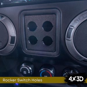 May include: Close-up of a black plastic panel with four round holes for rocker switches. The panel is mounted in a car dashboard. The text "4x3D" is visible in the lower right corner of the image.