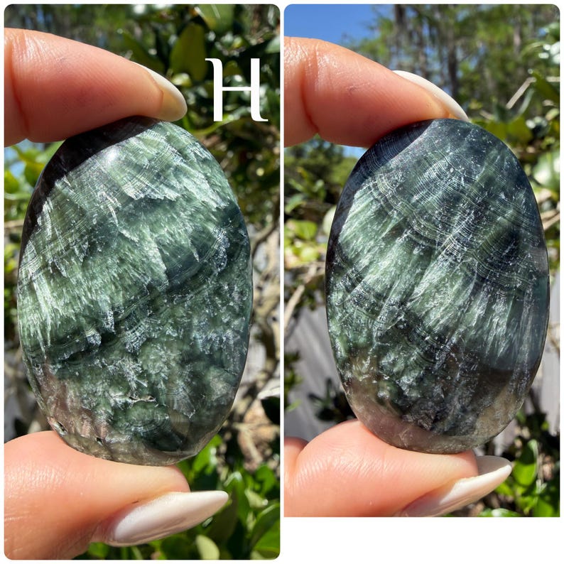May include: A polished, oval-shaped gemstone with a swirling pattern of dark green and white. The stone is held between fingers, showcasing its natural texture and color variations. The letter "H" is visible in the background.