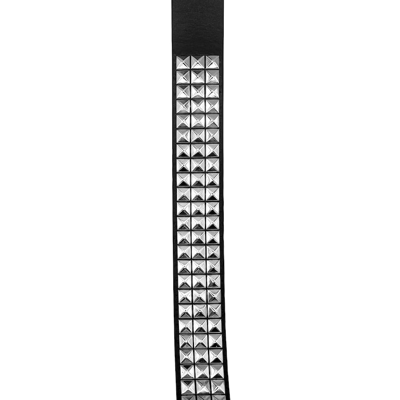May include: A black leather belt with silver pyramid-shaped studs.