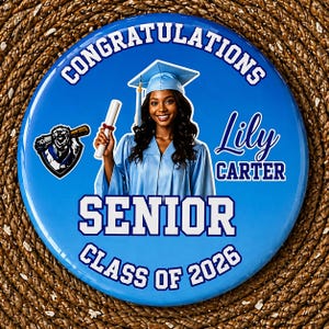 May include: A round, blue graduation button with the words "CONGRATULATIONS" and "SENIOR CLASS OF 2026". It features a graduate in a cap and gown, holding a diploma, with the name "Lily Carter". A baseball team logo is on the left.
