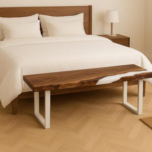 May include: A wooden bench with a live edge design and a white resin inlay. The bench has a dark brown finish and sits on white metal legs. The bench is placed at the foot of a bed with white bedding.