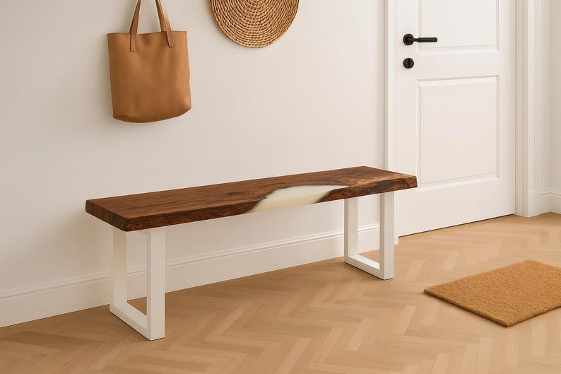 May include: A wooden bench with a live edge and white resin inlay. The bench has white metal legs and is approximately 60 inches long. A brown leather tote bag hangs on the wall above the bench.