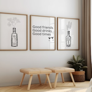 May include: Three framed prints with black and white illustrations of bottles and flowers. The center print has the text "Good friends Good drinks Good times" and two martini glasses.