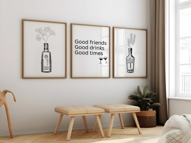 May include: Three framed prints with black and white illustrations of bottles and flowers. The center print has the text "Good friends Good drinks Good times" and two martini glasses.