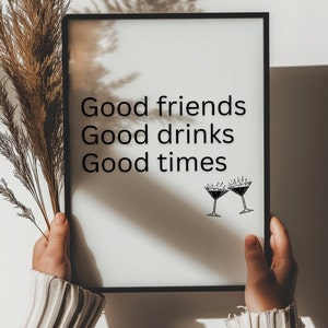 May include: A black framed print with the text "Good friends Good drinks Good times" and a drawing of two martini glasses with a starburst design above each glass.
