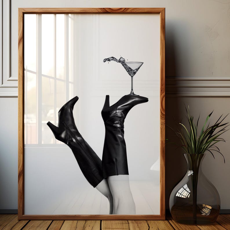 K&ouml;nnte beinhalten: Ein Schwarzwei&szlig;foto von einem Paar schwarzer Stiefel mit Abs&auml;tzen, die aufrecht stehen, wobei die Oberteile der Stiefel auf einem Martini-Glas ruhen. Das Glas ist mit Wasser gef&uuml;llt und es spritzt Wasser heraus.