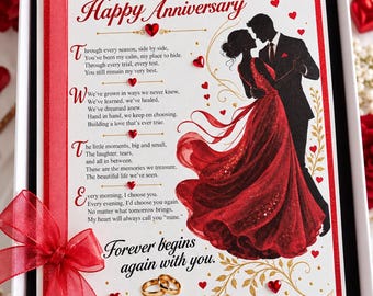May include: A white anniversary card in a box features a red ribbon, gold text, and a silhouette of a couple dancing. The text reads Peg Happy Anniversary, a poem, and Forever begins again with you. Small red heart embellishments and two gold rings are visible.
