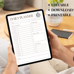May include: A digital daily planner displayed on a tablet. The planner features sections for schedule, top priorities, and goals. Text on the screen includes "Daily Planner," "Today's Schedule," and "Editable, Downloadable, Printable."