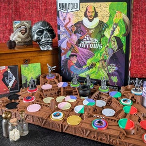 May include: A board game titled "Unmatched: Slings and Arrows" featuring a box with illustrations of characters and a game board with tokens and miniatures. Additional items include a skull, cards, and small bottles.