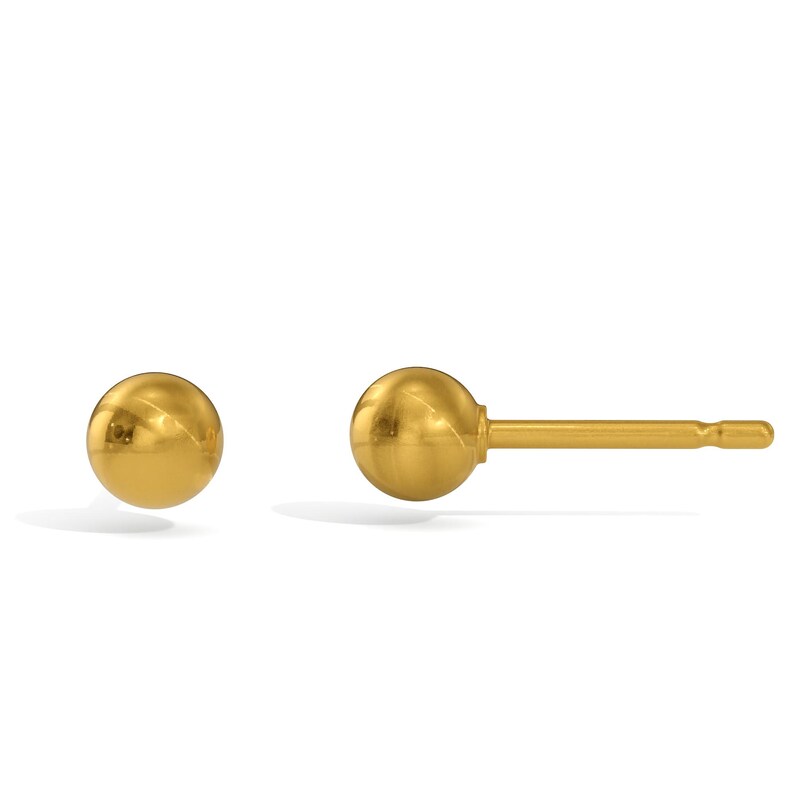 Pu&ograve; includere: Un paio di orecchini a lobo dorati a forma di sfera. Un orecchino &egrave; staccato, l'altro &egrave; mostrato con il perno. Gli orecchini hanno una superficie lucida e riflettente e un design semplice e classico.