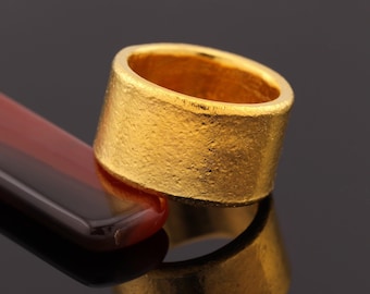 May include: A thick gold ring with a textured surface. The ring is made of solid gold and has a simple, elegant design.