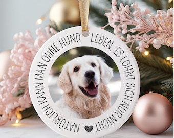 May include: White round ornament with a black border and the text "NATÜRLICH KANN MAN OHNE HUND LEBEN, ES LOHNT SICH NUR NICHT" in German. A photo of a golden retriever dog is in the center of the ornament.