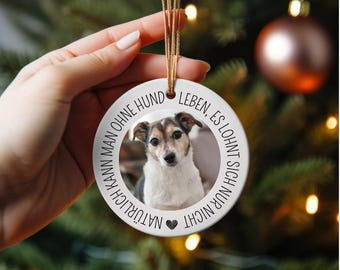 May include: White ceramic Christmas ornament with a photo of a dog and the text "NATÜRLICH KANN MAN OHNE HUND LEBEN, ES LOHNT SICH NUR NICHT."