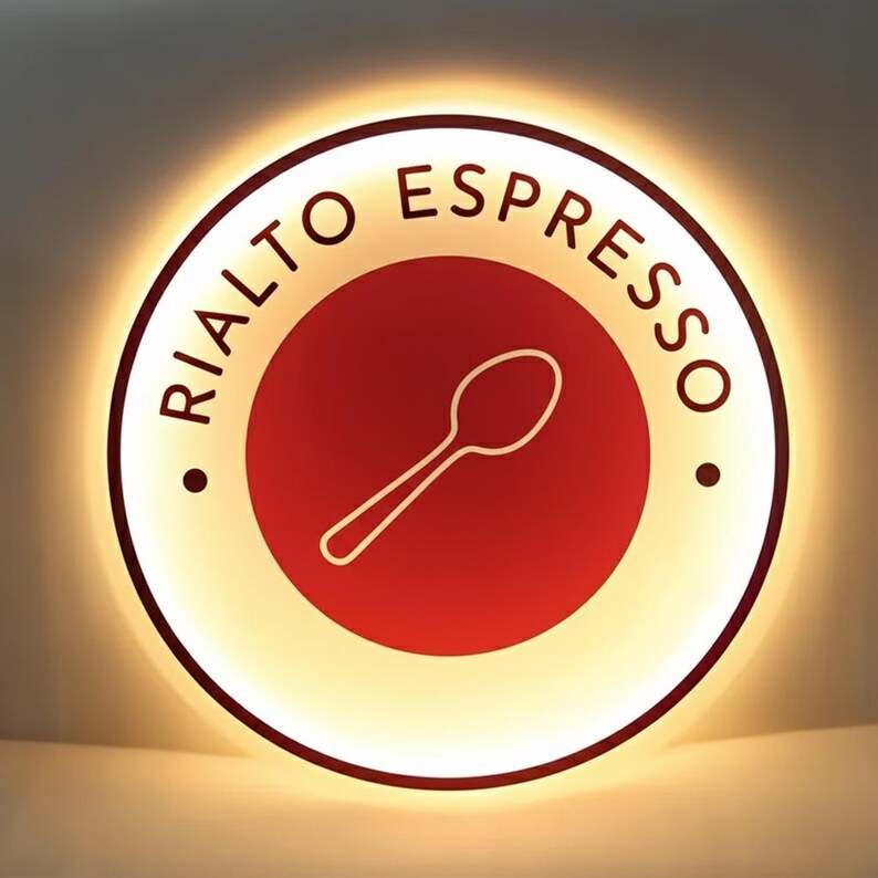 May include: Circular sign with the text "RIALTO ESPRESSO" in a curved font. The sign has a red center with a white spoon graphic. The outer ring is white with a warm, glowing light.