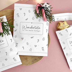 May include: Three white paper bags with black line drawings of holiday icons. Each bag features a rectangular label with the text Wundertüte and specific recipients. Decorations include small pine sprigs and candy canes. Text includes DIY WUNDERTÜTE WEIHNACHTEN, 15 VARIANTEN FÜR KOLLEGEN, FREUNDE & FAMILIE, PDF, SOFORT DOWNLOAD PRINT A4.