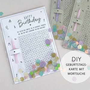 May include: A DIY birthday card with a word search puzzle, featuring the words "Happy Birthday" in elegant script. The card includes a pink candle and confetti. The text on the card is in German.